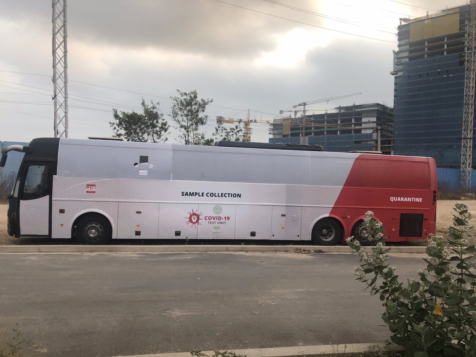 Full side view of iMASQ COVID-19 Test Unit bus · SAMPLE COLLECTION wing in white · QUARANTINE wing in red · COVID-19 iMASQ red logo · clean infrastructure design